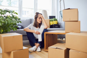 Worried woman among her moving boxes.