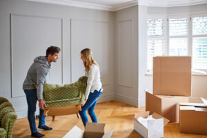Young couple moving a couch into their new home