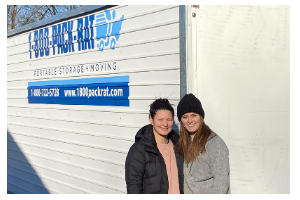 Two women standing in front of a moving container