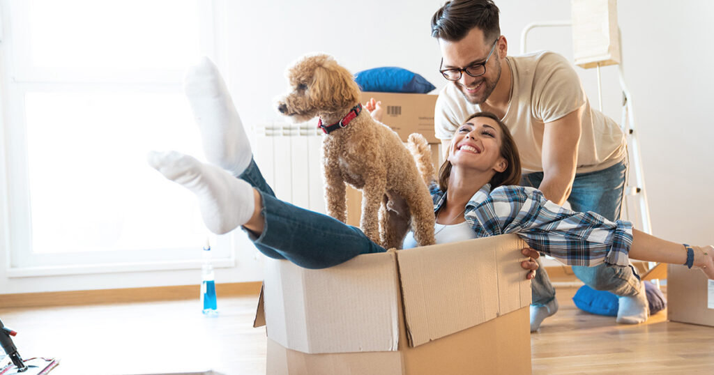 Couple with moving boxes and a dog