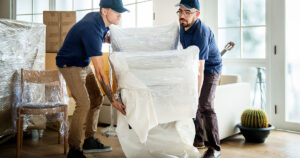 Two professional packers carrying an armchair