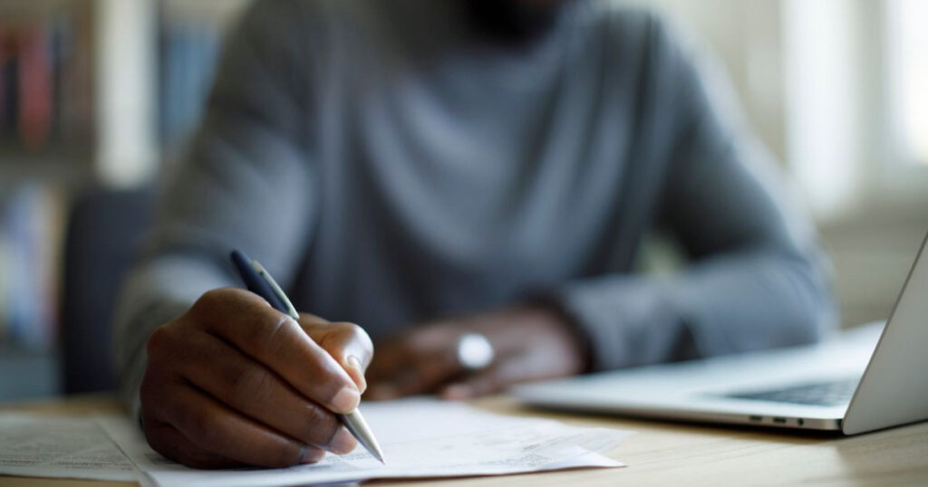 Man filling out paperwork at a desk