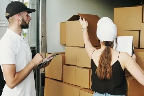 Two people loading a moving van.