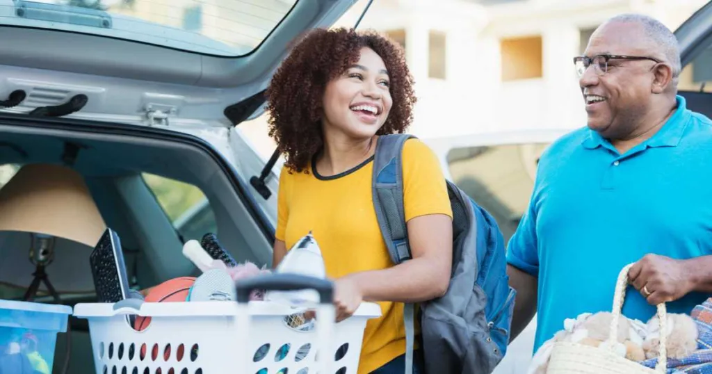 We're here to help make your move to college easier. A mature African-American man helping his daughter relocate, perhaps into an apartment or college dorm.