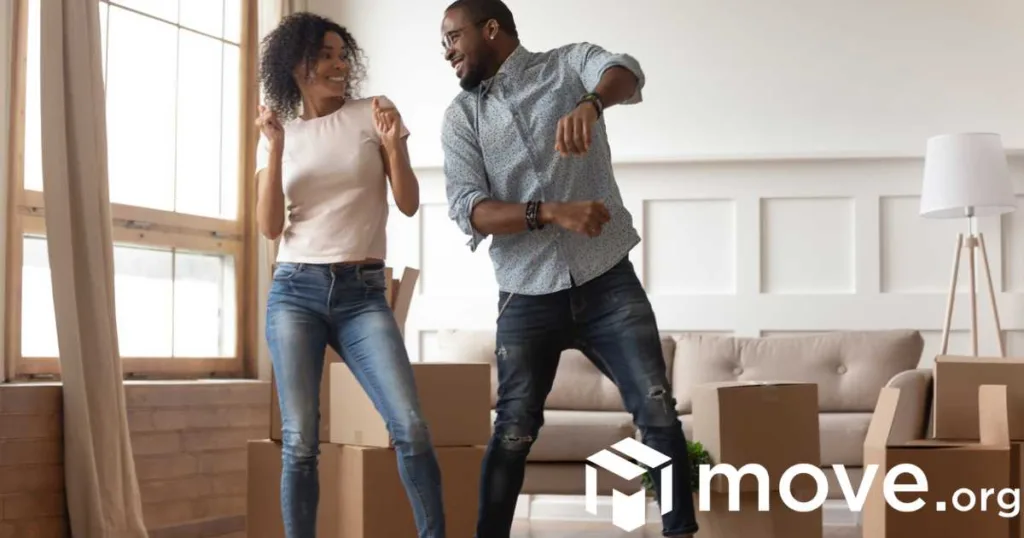 A man and a woman dancing together in a room with boxes.