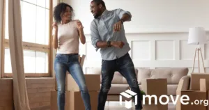 A man and a woman dancing together in a room with boxes.
