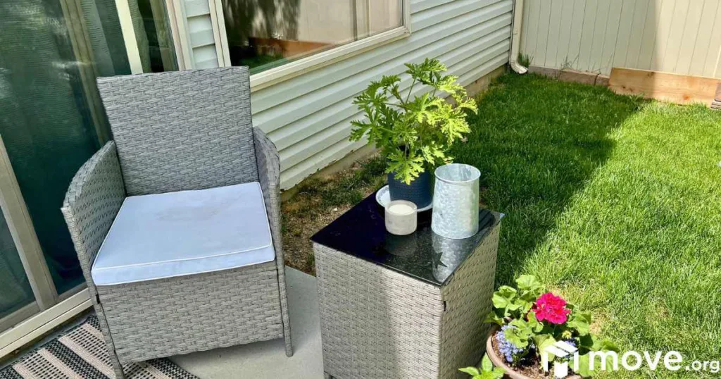 Outside patio furniture and plants make a cozy, outdoor reading nook.