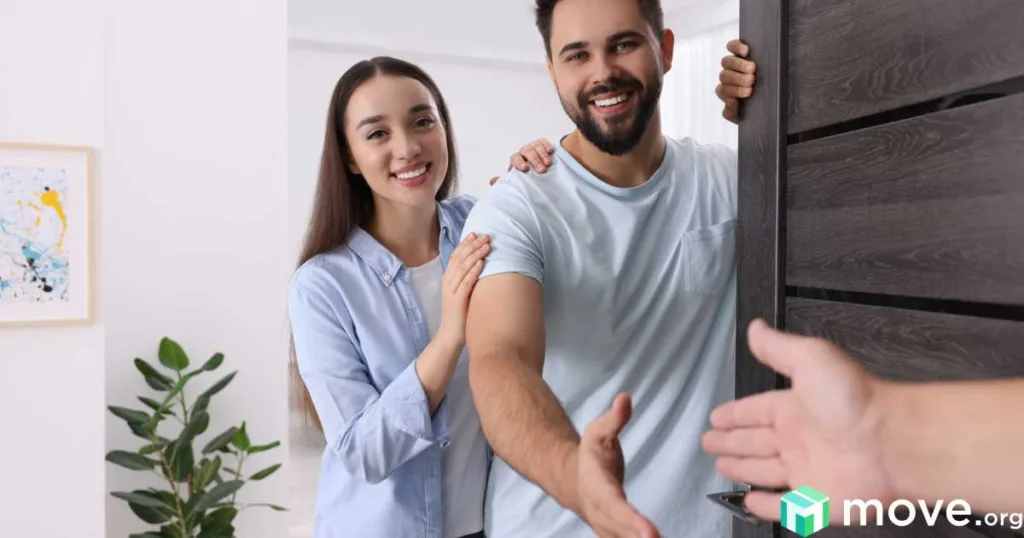Happy couple welcoming a new neighbor at the front door.